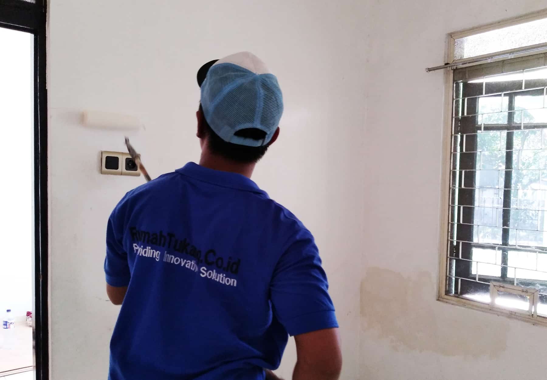 mitra Sejasa sedang melakukan pengecatan dinding