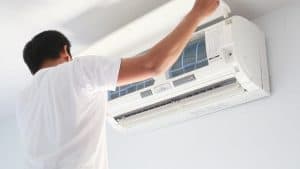 membersihkan filter AC secara rutin agar bisa hemat tagihan listrik 