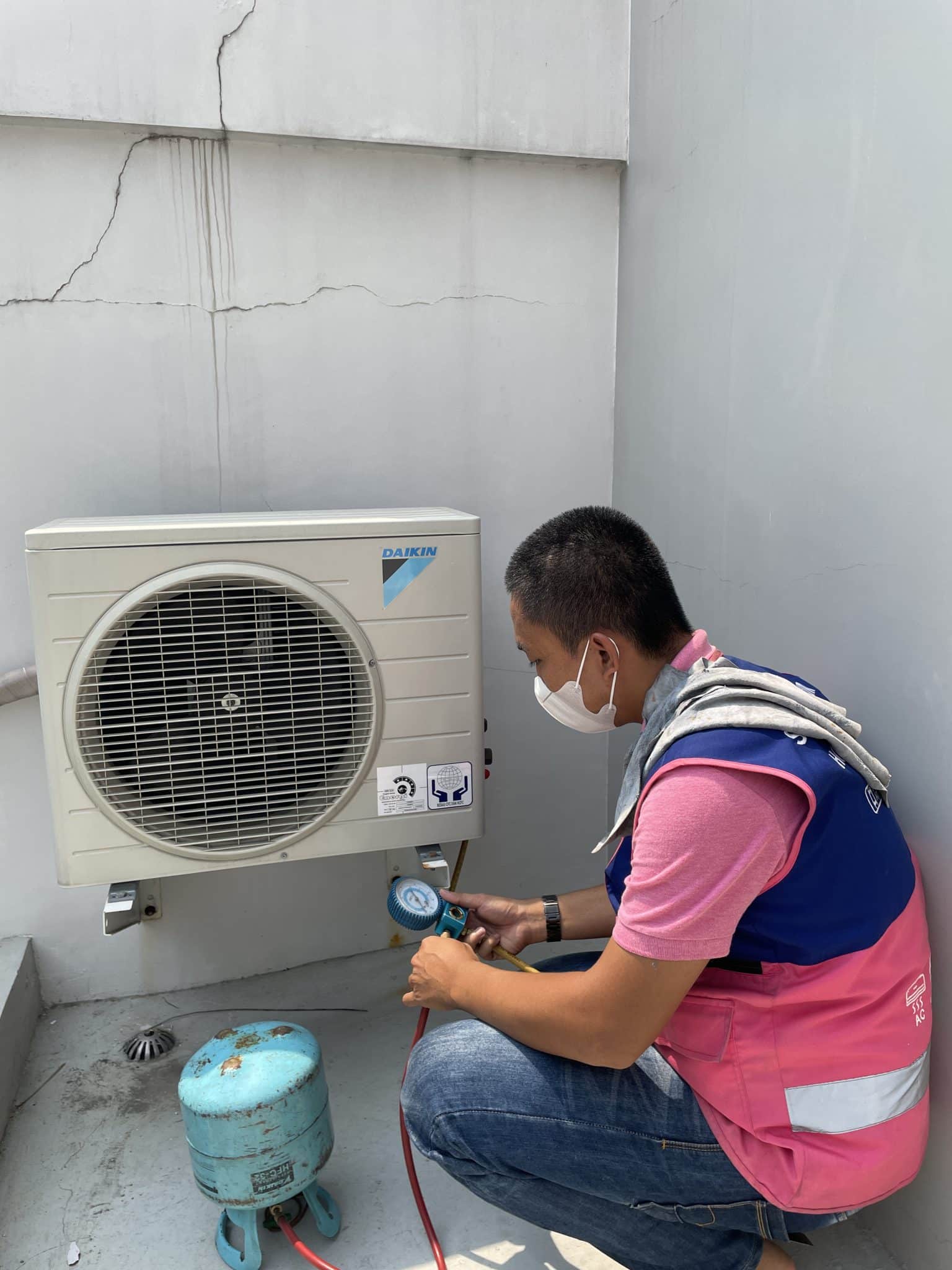 tenisi Sejasa sedang mengecek kadar refrigerant atau freon pada AC untuk mengecek penyebab AC tidak dingin