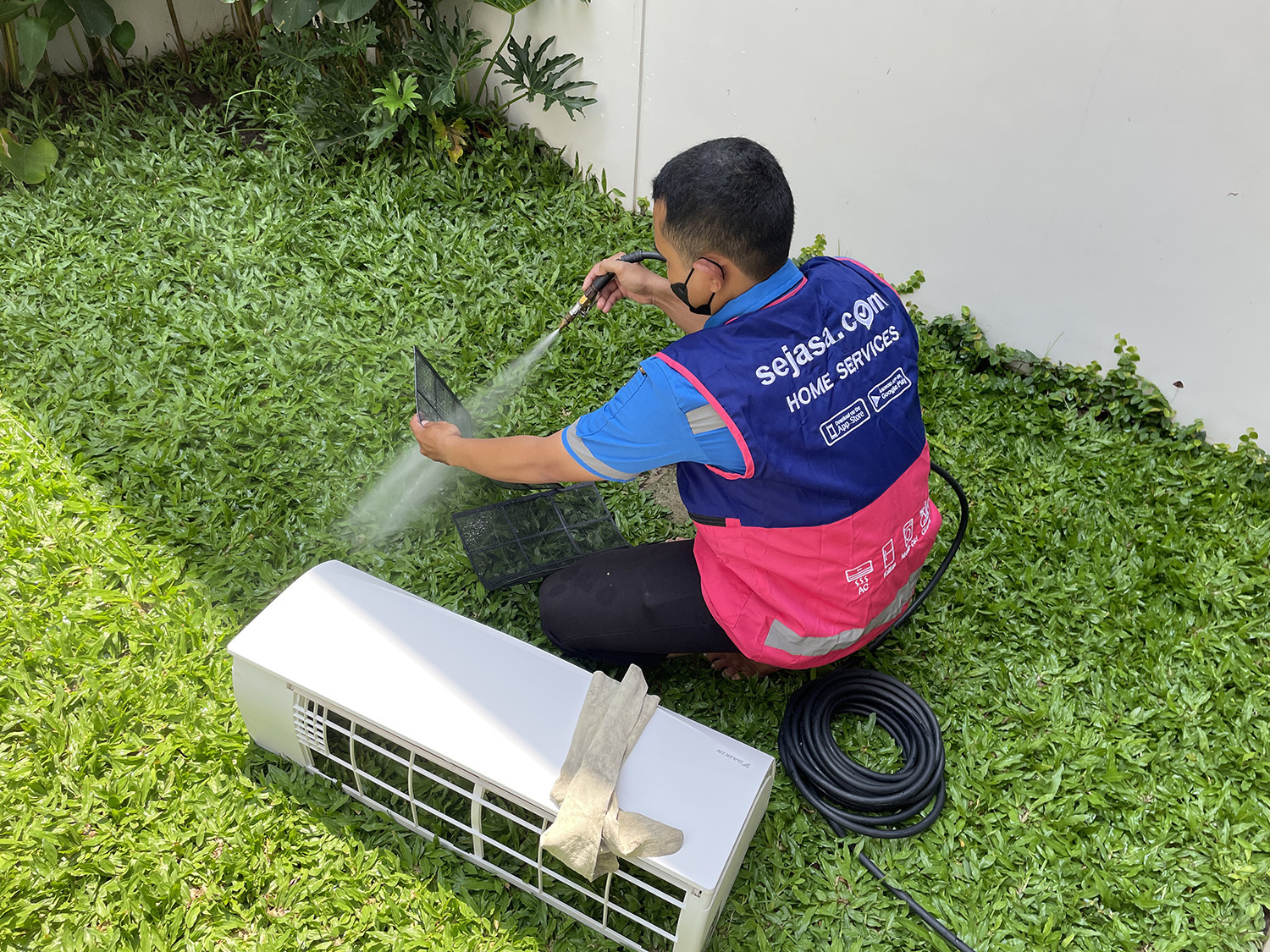 teknisi Sejasa sedang membersihkan filter AC dan service AC