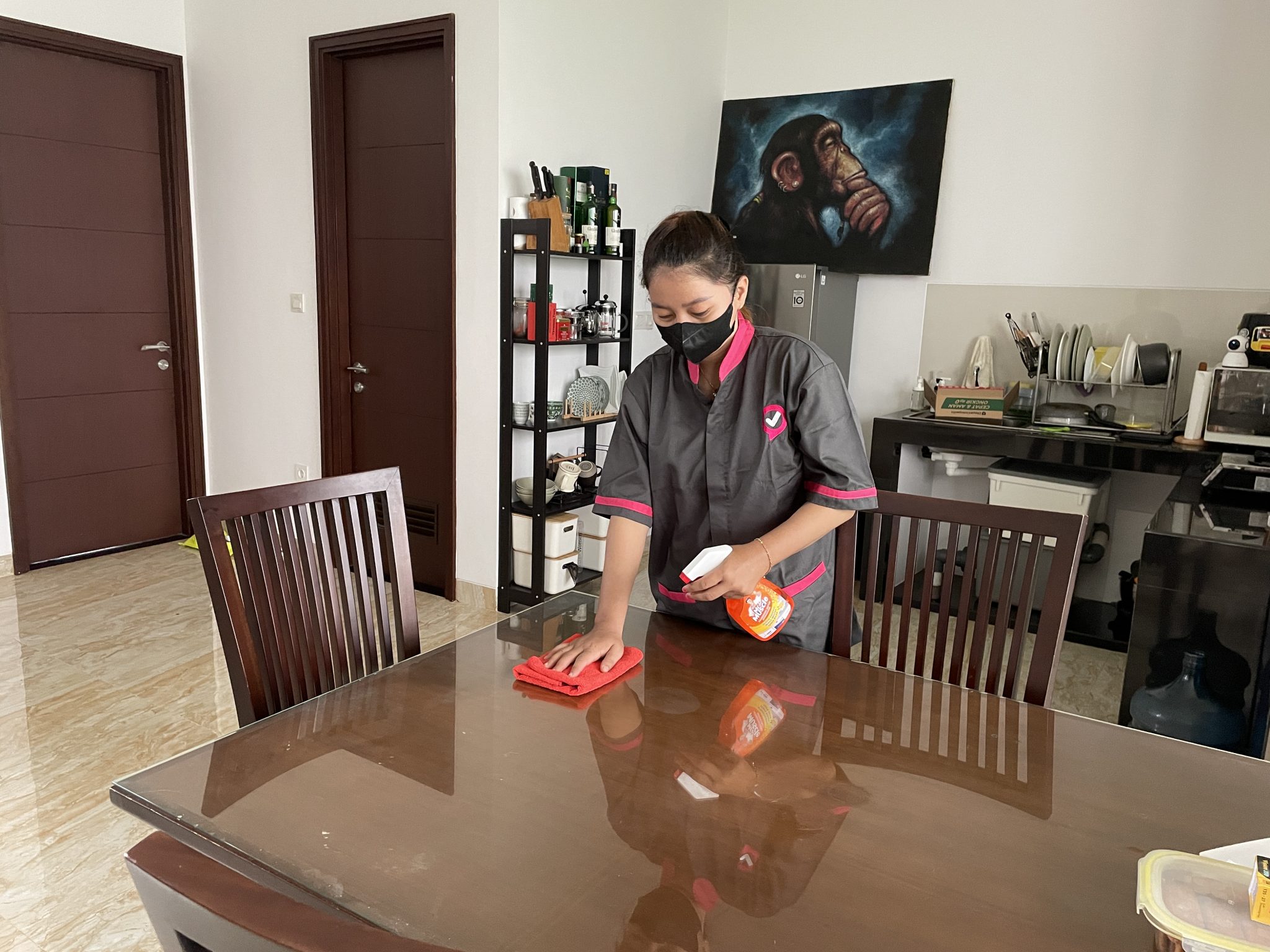 penyedia jasa Sejasa sedang membersihkan permukaan meja makan 