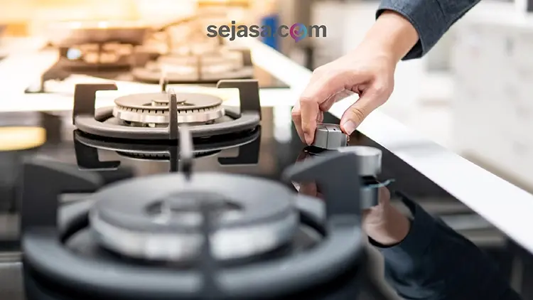 seseorang yang hendak menyalakan kompor gas